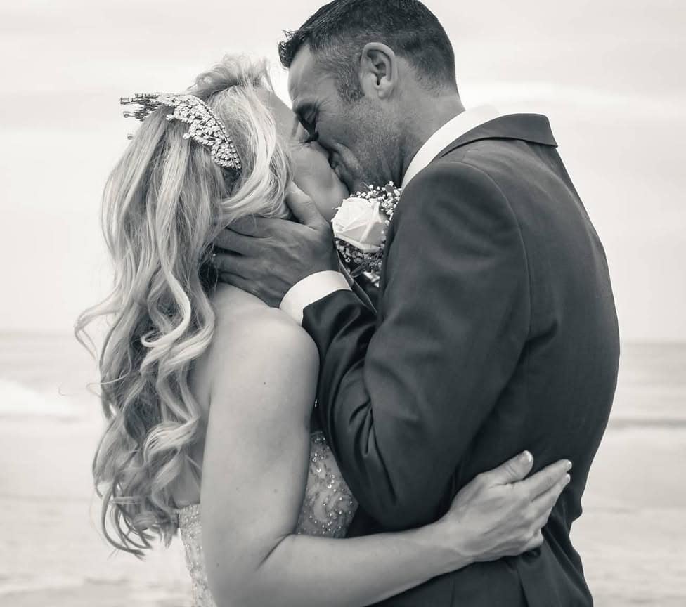 Newlyweds kissing on the beach